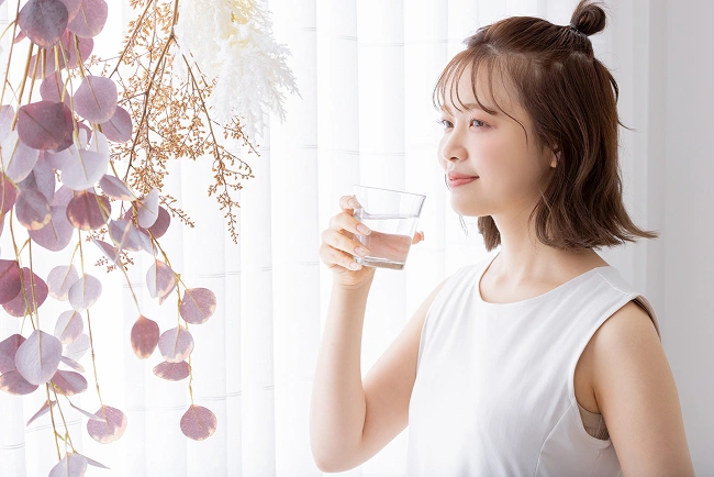 サプリメントを飲む女性のイメージ画像